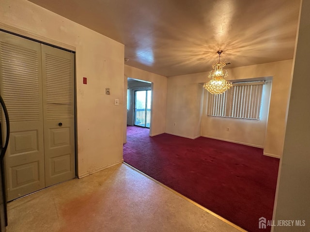 empty room featuring a notable chandelier and finished concrete floors