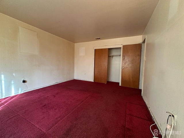 unfurnished bedroom featuring visible vents and dark colored carpet