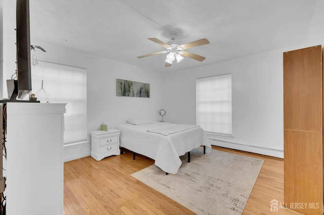 323 Gill Ln Unit 11Q, Iselin, NJ 07067 - bedroom featuring a baseboard heating unit, wood finished floors, a ceiling fan, and baseboards
