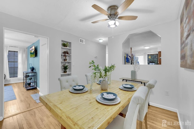 323 Gill Ln Unit 11Q, Iselin, NJ 07067 - dining room featuring a ceiling fan, wood finished floors, arched walkways, and baseboards