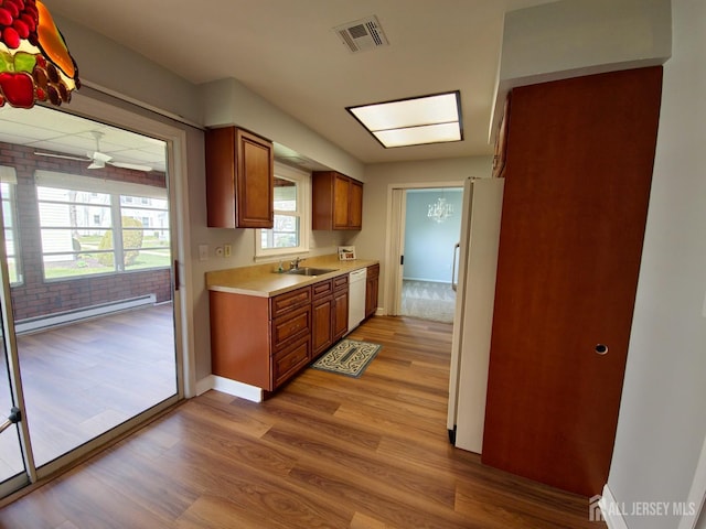 467 New Haven Way Unit A, Monroe, NJ 08831 - kitchen featuring white appliances, a baseboard radiator, light wood-type flooring, light countertops, and brown cabinetry