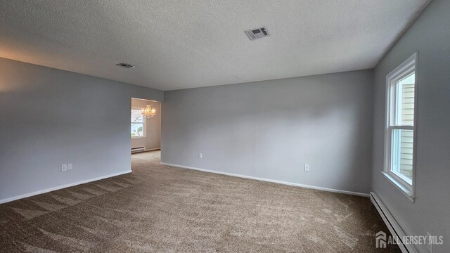 467 New Haven Way Unit A, Monroe, NJ 08831 - empty room featuring a chandelier, carpet floors, a textured ceiling, baseboard heating, and baseboards