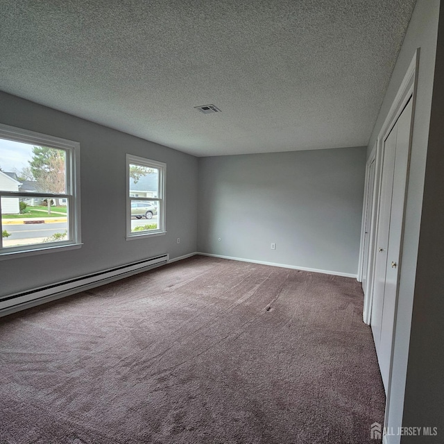 467 New Haven Way Unit A, Monroe, NJ 08831 - unfurnished bedroom with carpet floors, a baseboard radiator, a textured ceiling, baseboards, and a closet