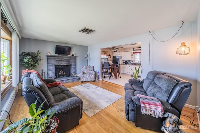 119 Carteret Ave, Carteret, NJ 07008 - living room featuring a fireplace, light wood finished floors, a baseboard heating unit, and ceiling fan