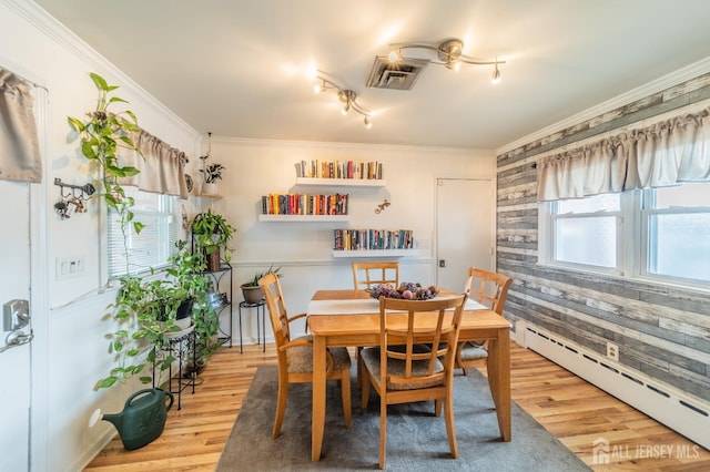 119 Carteret Ave, Carteret, NJ 07008 - dining area featuring a baseboard heating unit, wood finished floors, track lighting, and ornamental molding