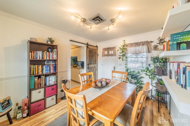 119 Carteret Ave, Carteret, NJ 07008 - dining area with a barn door, crown molding, wood finished floors, and track lighting