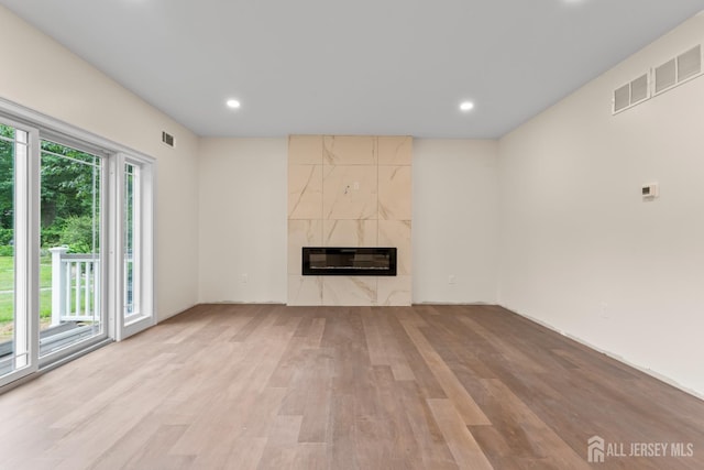 38 Louise Dr, East Brunswick, NJ 08850 - unfurnished living room with heating unit, light wood finished floors, a premium fireplace, and recessed lighting