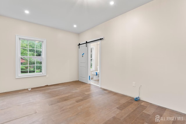 38 Louise Dr, East Brunswick, NJ 08850 - unfurnished room featuring a barn door, light wood-style flooring, and recessed lighting