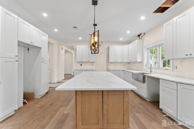 38 Louise Dr, East Brunswick, NJ 08850 - kitchen featuring recessed lighting, light stone countertops, light wood-type flooring, a kitchen island, and white cabinetry