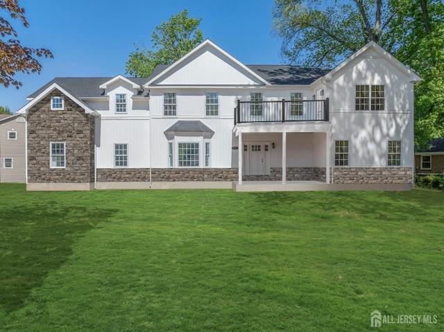 38 Louise Dr, East Brunswick, NJ 08850 - rear view of house with stone siding, a balcony, and a lawn