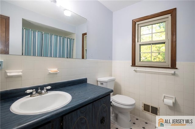 11 Gunpowder Dr, East Brunswick, NJ 08816 - bathroom with tile walls, tile patterned floors, vanity, a wainscoted wall, and a shower with curtain