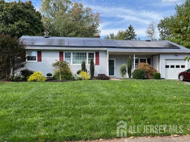 ranch-style house with solar panels, a front lawn, and a garage