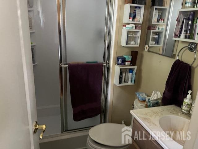 bathroom with vanity, toilet, and an enclosed shower