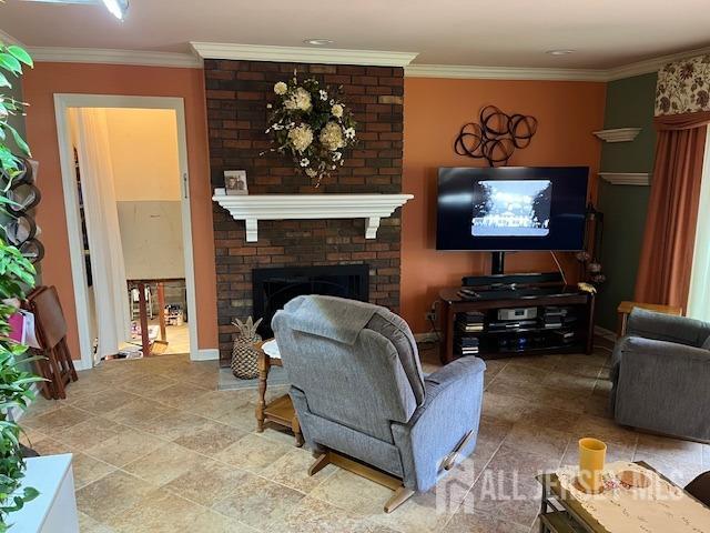 living room featuring crown molding and a brick fireplace