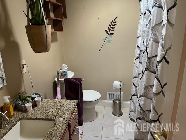 full bath with visible vents, toilet, vanity, baseboards, and tile patterned floors