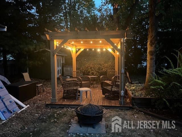 view of patio / terrace with a fire pit, a deck, and a pergola