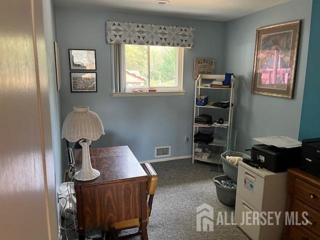 office area featuring carpet floors, baseboards, and visible vents