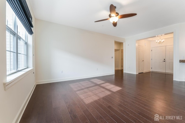 7209 Minuteman Ln, Franklin, NJ 08873 - empty room featuring dark wood-style flooring, a chandelier, a ceiling fan, and baseboards
