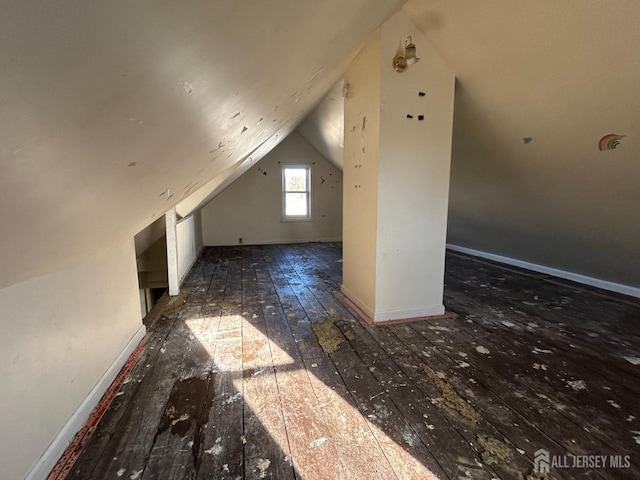 additional living space with dark hardwood / wood-style flooring and lofted ceiling