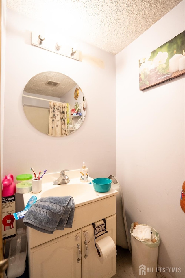 bathroom featuring a textured ceiling and vanity