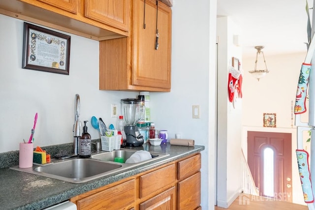 kitchen with dark countertops, dishwasher, and a sink