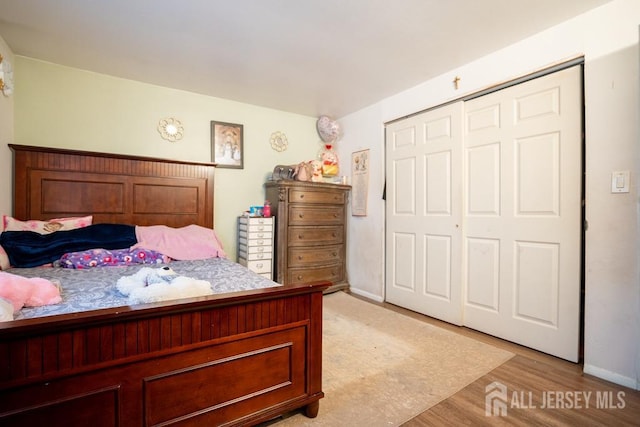 bedroom with light wood-type flooring and a closet