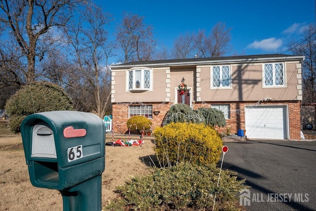 bi-level home with an attached garage, stucco siding, and brick siding