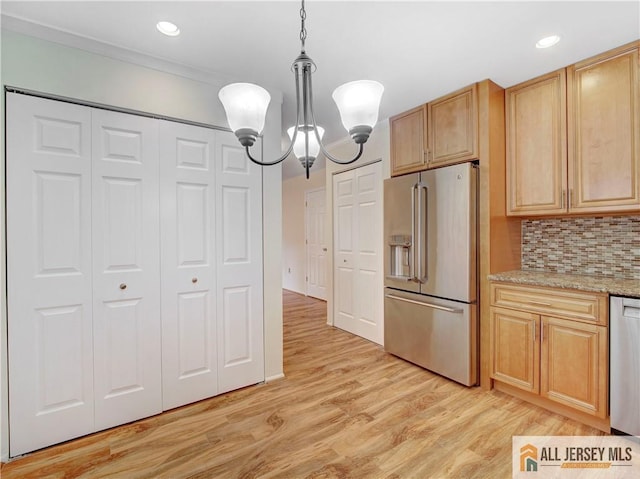 kitchen with appliances with stainless steel finishes, tasteful backsplash, a notable chandelier, light brown cabinetry, and decorative light fixtures