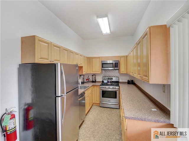 kitchen featuring stainless steel appliances, light brown cabinetry, and decorative backsplash