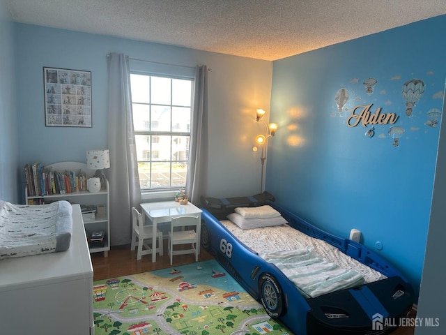 bedroom with wood finished floors and a textured ceiling