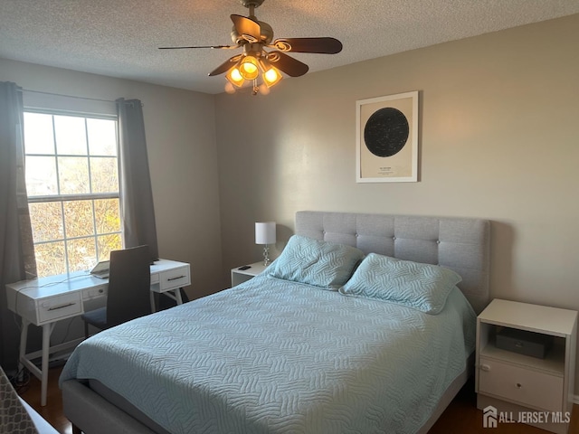 bedroom featuring ceiling fan and a textured ceiling