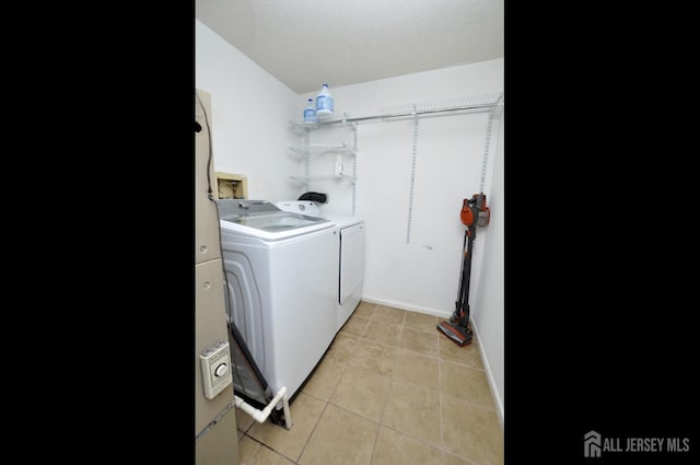 laundry area with laundry area, light tile patterned flooring, and washing machine and dryer