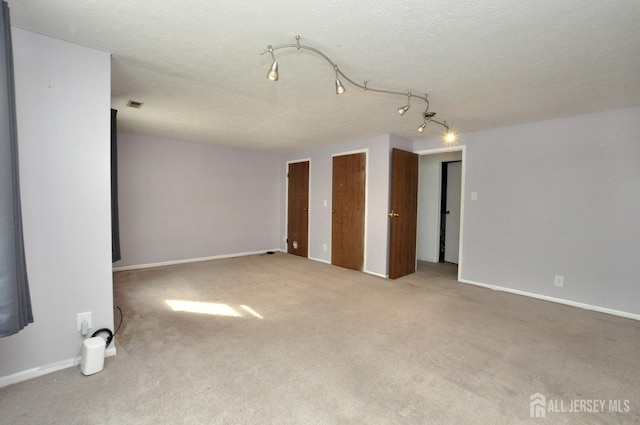 empty room with carpet floors and a textured ceiling