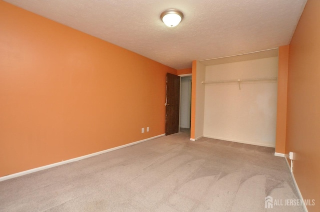 unfurnished bedroom with carpet floors, a closet, a textured ceiling, and baseboards