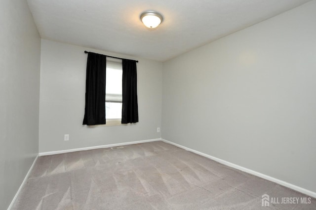 unfurnished room featuring light colored carpet