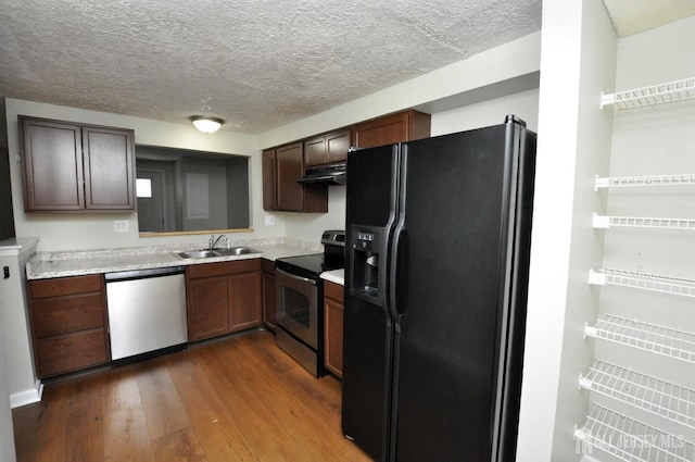 kitchen featuring hardwood / wood-style floors, sink, stainless steel appliances, dark brown cabinets, and a textured ceiling