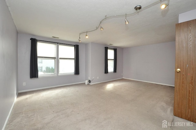 carpeted empty room with a textured ceiling