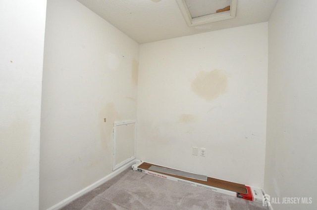 laundry area with attic access, baseboards, and light colored carpet