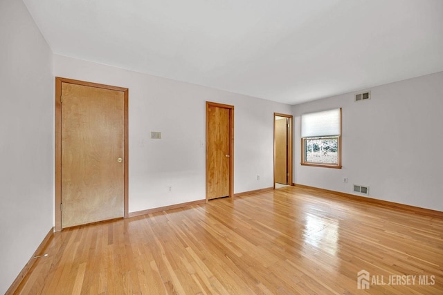 interior space featuring light wood-style flooring, visible vents, and baseboards