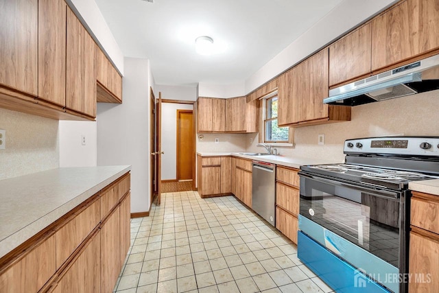 kitchen featuring stainless steel appliances, light countertops, under cabinet range hood, a sink, and light tile patterned flooring