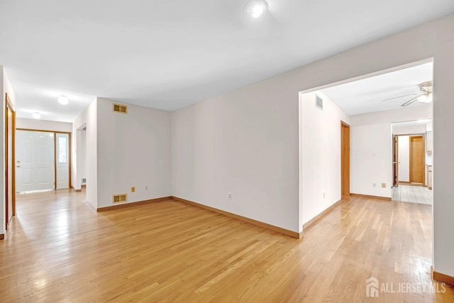 spare room with baseboards, visible vents, and light wood finished floors