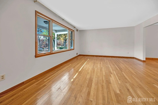 empty room featuring light wood-type flooring and baseboards