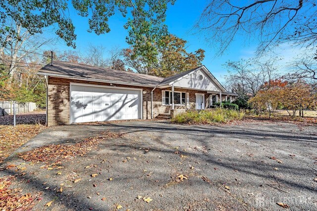 single story home with a porch and a garage