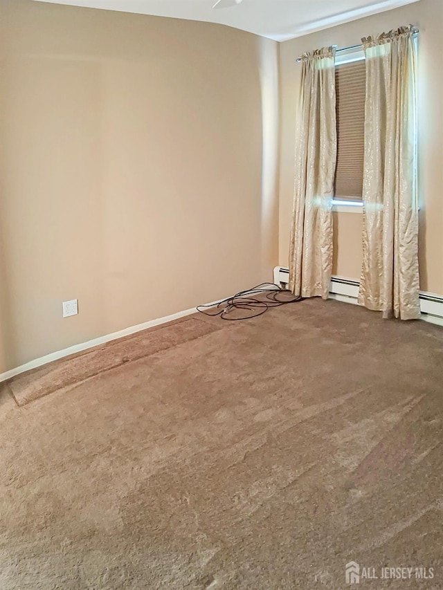 empty room with carpet floors and a baseboard heating unit