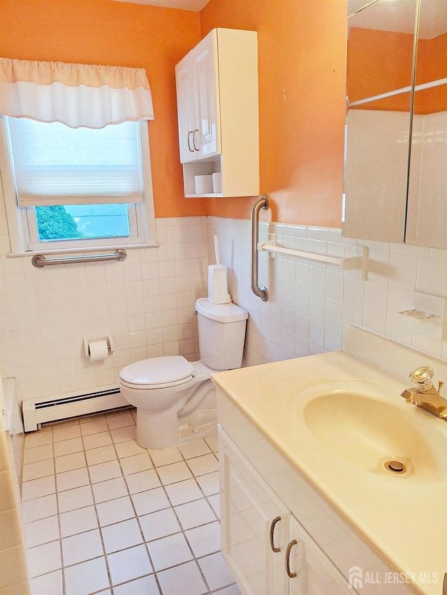 bathroom featuring tile patterned floors, vanity, a baseboard radiator, and tile walls