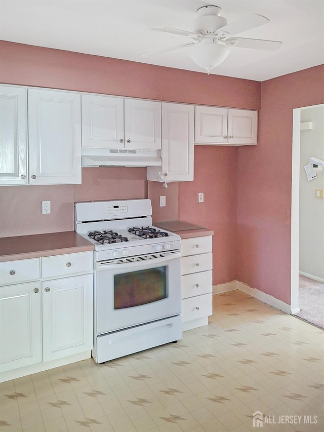 kitchen with white cabinetry, gas range gas stove, and ceiling fan