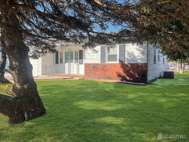 view of front of property featuring a front yard and central air condition unit