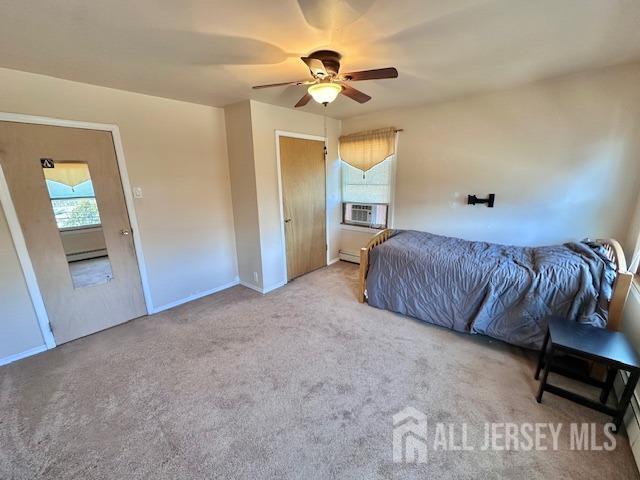 carpeted bedroom with baseboard heating, a baseboard radiator, cooling unit, ceiling fan, and baseboards