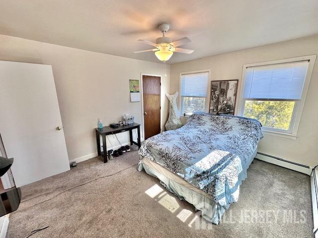 carpeted bedroom with baseboard heating, baseboards, and a ceiling fan