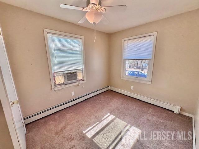 unfurnished room featuring baseboard heating, cooling unit, a ceiling fan, and carpet